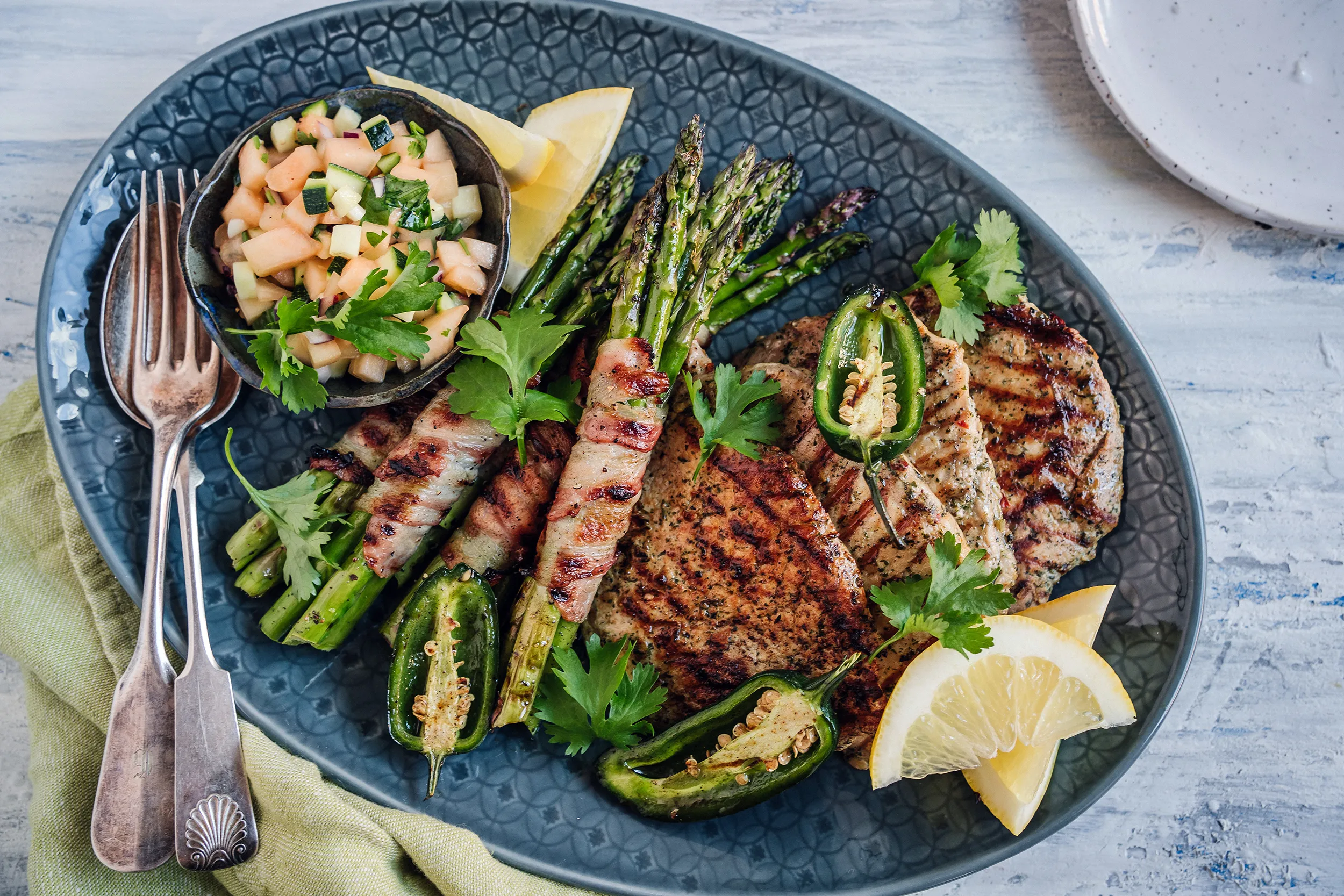 Grillad filébiff av lantgris med somrig zucchinicantaloupesalsa och baconlindad sparris