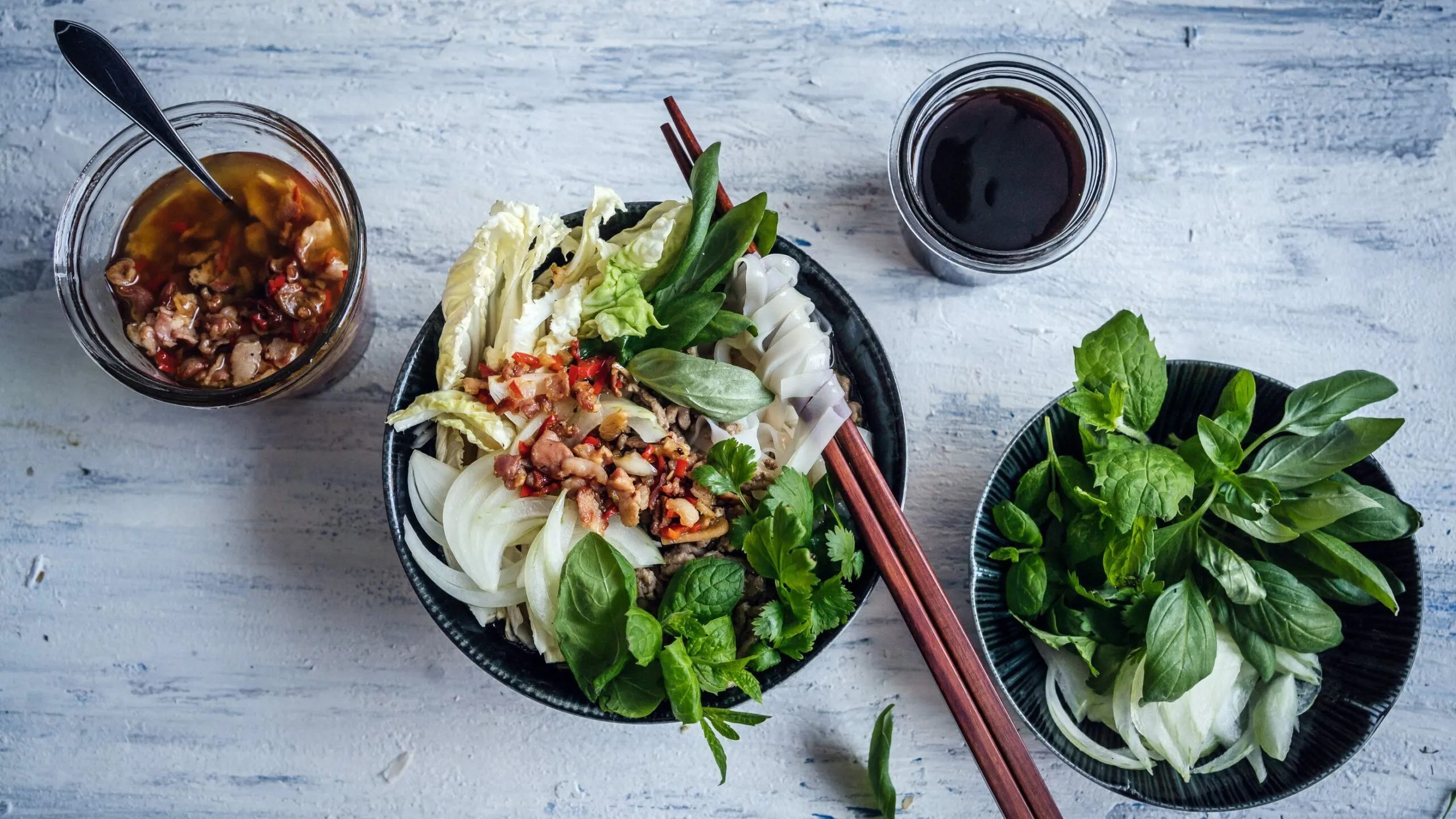 Vietnamesisk phở med malet kött och olja på chili och bacon